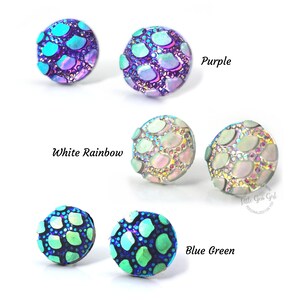 May include: Six pairs of iridescent round earrings with a scale-like pattern. The earrings are in the colors purple, white rainbow, and blue green.