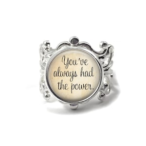 May include: Silver ring with a round, white cameo featuring the text "You've always had the power."