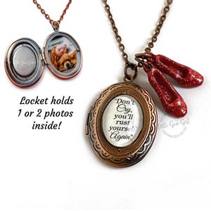 Op de afbeelding: Een koperen ketting met een medaillon met daarin een citaat dat luidt: "Huil niet, je zult jezelf weer roesten". Het medaillon heeft een klein paar rode glitter-schoenen eraan bevestigd. Het medaillon kan een of twee foto's bevatten.