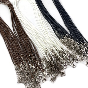 May include: A collection of brown, white, and black cords with silver clasps. The cords are arranged in a pile, with the clasps at the bottom.