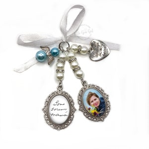 May include: A silver charm featuring a photo of a woman with the inscription "Love forever, Mama" on one side and a silver heart charm with the inscription "You are always in my heart" on the other. The charm is attached to a white ribbon and a string of white and blue beads.