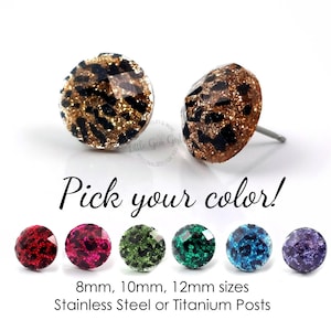 May include: Leopard print glitter stud earrings in various colors, including red, pink, green, blue, and purple. The earrings are available in 8mm, 10mm, and 12mm sizes with stainless steel or titanium posts. "Pick your color!" text is displayed below the earrings.