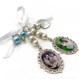 May include: A silver charm with a white ribbon, a heart charm with the text "Forever in my heart", a string of white pearls, a blue angel charm, and two oval photo charms. One photo charm features a dog, and the other features a family.