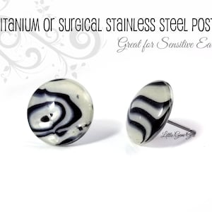 以下が含まれることがあります： 白と黒の渦巻き模様のスタッドピアス2つ。「Titanium or Surgical Stainless Steel Posts」と「Great for Sensitive Ears!」の文字が入っています。