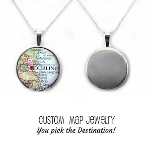 May include: A silver-toned necklace with a round pendant featuring a map of Dublin, Ireland. The pendant shows the city's layout with streets and landmarks. The text "CUSTOM MAP JEWELRY You pick the Destination!" is below the necklaces.