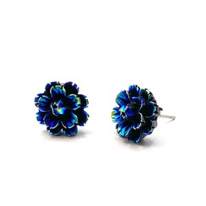Op de afbeelding: Een paar blauwe, bloemvormige oorbelletjes met een zilveren pin.
