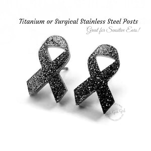 May include: A pair of black glitter awareness ribbon stud earrings with titanium or surgical stainless steel posts. The text Titanium or Surgical Stainless Steel Posts and Great for Sensitive Ears! is visible above the earrings.