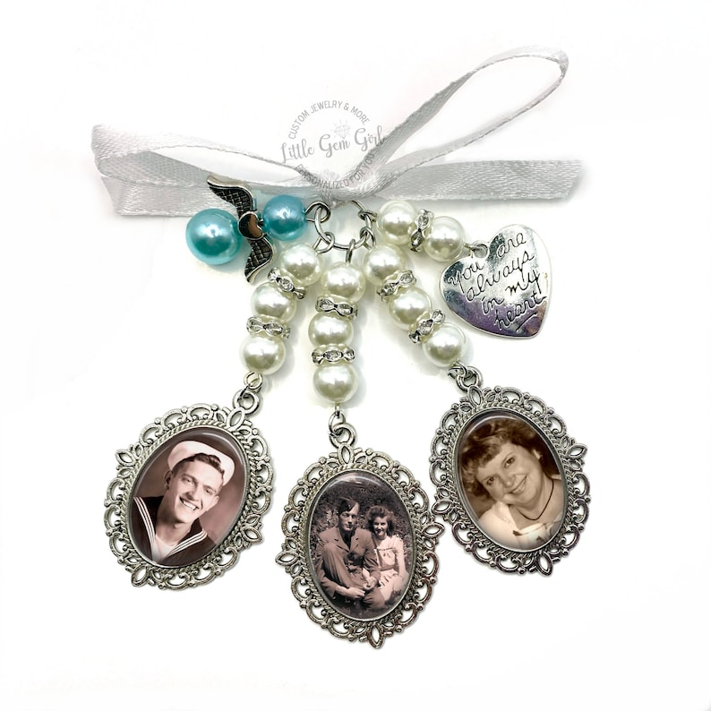 May include: A white pearl and rhinestone charm with three silver oval frames containing black and white photos. The charm also includes a silver heart charm with the text "You are always in my heart".