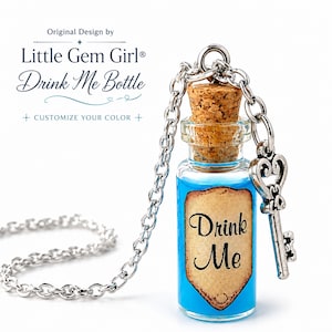 May include: A clear glass bottle pendant filled with bright blue liquid, sealed with a cork stopper. A tan shield-shaped label with the text Drink Me is attached to the front. The bottle hangs from a silver chain with a decorative skeleton key charm.