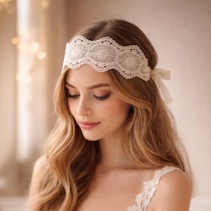 May include: A cream-colored lace headband with a floral design and a delicate bow. The headband is worn across the forehead. The woman has long, wavy blonde hair and is wearing a cream-colored top.