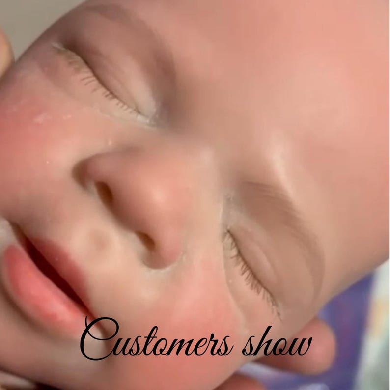 May include: Close-up of a baby's face with closed eyes and rosy cheeks. The baby's lips are slightly parted, and the skin has a soft, realistic texture. The text "Customers show" is written in cursive at the bottom of the image.