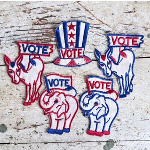 May include: Five embroidered fabric patches featuring political themes. One patch is a top hat with red stars and stripes. Two patches depict donkeys with blue and red outlines holding VOTE signs. Two patches show elephants with red and blue outlines holding VOTE signs.