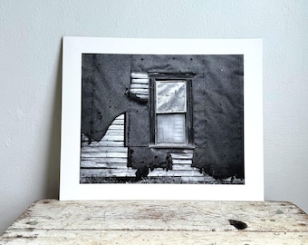 Fotografía vintage en blanco y negro de un edificio abandonado y deteriorado.