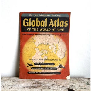 May include: Vintage "Global Atlas of the World at War" book. The cover features a world map in yellow and orange, with text in black and yellow. The book's title is prominently displayed, along with text about invasion maps and military movements.