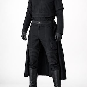 May include: All-black outfit featuring a short-sleeved top with vertical stitching, matching pants with knee padding, a long skirt, gloves, and tall boots. The ensemble is a dark, monochromatic design.