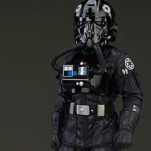 May include: A black TIE fighter pilot costume. The costume includes a glossy black helmet with white insignia, a chest piece with a control panel, and a black jumpsuit with pockets. The pilot also wears black gloves and boots. The costume is from the Star Wars franchise.