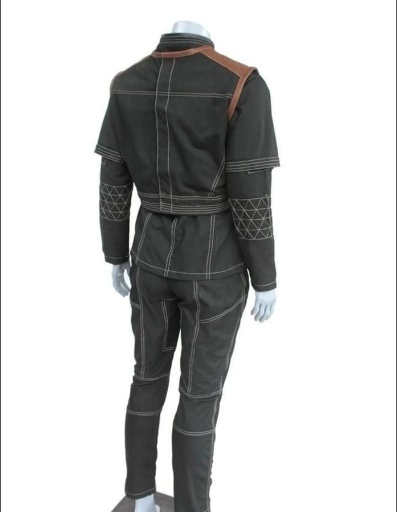 May include: A black two-piece outfit consisting of a jacket and pants with prominent white contrast stitching. The jacket features brown shoulder panels and a geometric triangular pattern on the sleeves. The pants have a matching seam design.