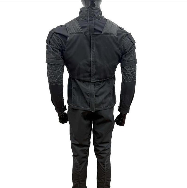 May include: A black tactical jacket and pants set. The jacket features reinforced shoulder and elbow patches, with a high collar and multiple pockets. The pants have a slim fit. The outfit is designed for durability and functionality.