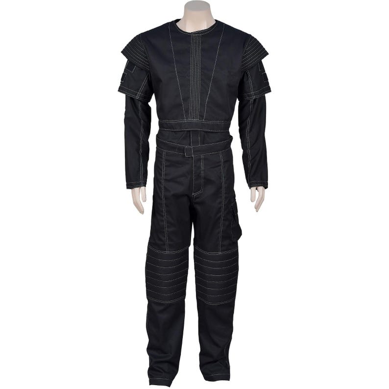 Puede incluir: Mono negro con costuras blancas. La parte superior de manga larga presenta detalles en los hombros y cuello redondo. Los pantalones tienen rodilleras reforzadas y un bolsillo cargo. El conjunto se exhibe en un maniqu&iacute;.