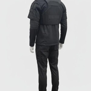 Puede incluir: Conjunto de uniforme t&aacute;ctico negro, que incluye una camisa de manga larga, pantalones cargo y un chaleco con protecci&oacute;n para hombros y pecho. El uniforme est&aacute; dise&ntilde;ado para la funcionalidad y durabilidad.