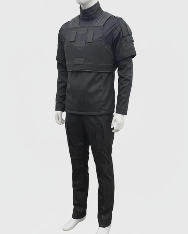 Puede incluir: Traje t&aacute;ctico negro sobre un maniqu&iacute;. El traje incluye una camisa de manga larga, un chaleco t&aacute;ctico y pantalones. El chaleco tiene m&uacute;ltiples paneles rectangulares. Los pantalones tienen bolsillos en los muslos. El traje se muestra sobre un fondo blanco.