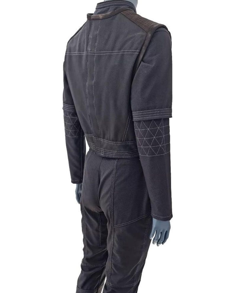 May include: Dark gray jumpsuit with white stitching details. Features include a stand-up collar, shoulder pads, and geometric patterns on the sleeves. The jumpsuit has a fitted waist and straight-leg pants.