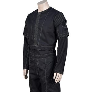 Puede incluir: Mono negro con costuras blancas. La prenda presenta cuello redondo, mangas largas y un dise&ntilde;o estructurado con m&uacute;ltiples paneles y bolsillos. Las costuras blancas proporcionan un acento de contraste.