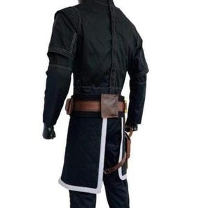 Op de afbeelding: Zwart kostuum met een jas, broek en riem met zakjes. De jas heeft lange mouwen en witte stiksels. De broek heeft een witte bies. De riem is bruin met een bruin zakje.
