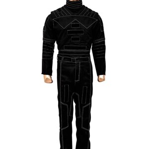 K&ouml;nnte beinhalten: Schwarzer Overall mit wei&szlig;en Steppdetails. Das Outfit hat einen hohen Kragen, lange &Auml;rmel und eine taillierte Silhouette. Das Design umfasst geometrische Formen und Linien, die einen strukturierten Look erzeugen. Der Overall wird auf einer Schaufensterpuppe pr&auml;sentiert.