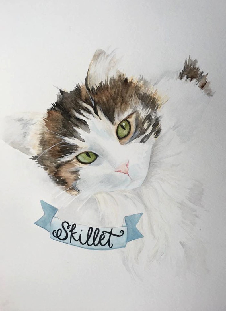 May include: Watercolour painting of a cat with green eyes and brown and white fur. The cat is looking at the viewer and has a blue ribbon around its neck with the word "Skillet" written on it.