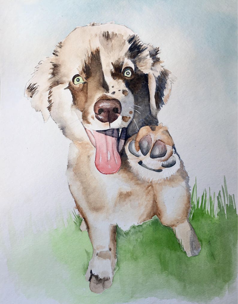 May include: Watercolour painting of a brown and white dog with green eyes, sticking out its tongue and raising its paw. The dog is sitting on a green grassy background.
