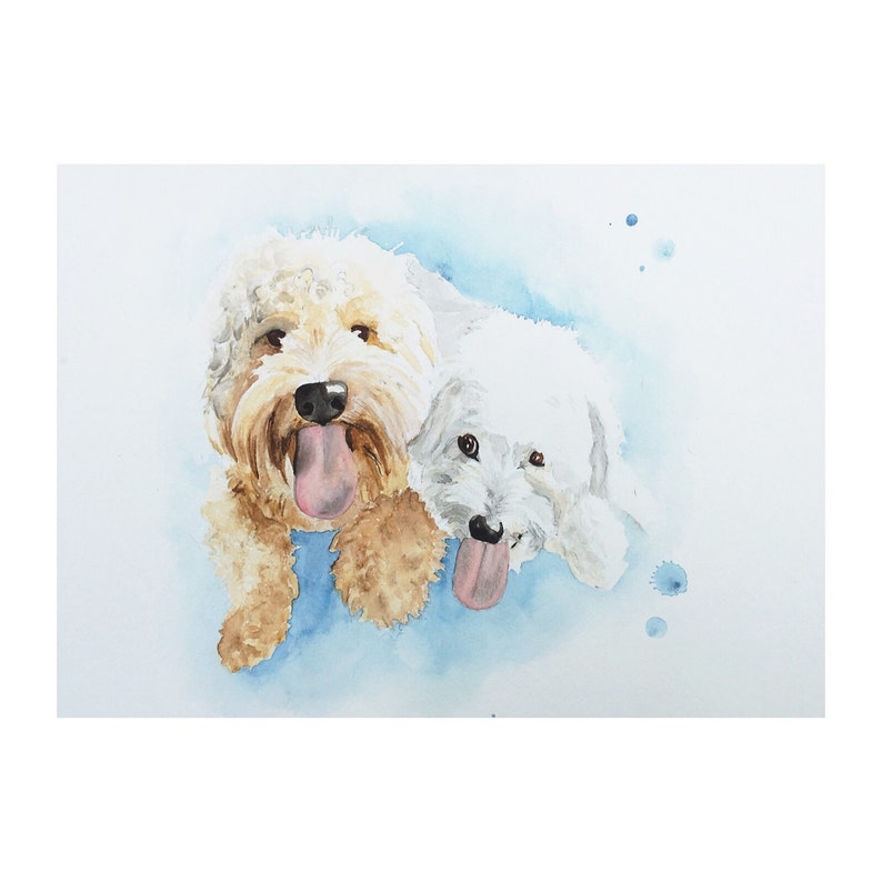 May include: Watercolour painting of two dogs, one white and one brown, with their tongues sticking out. The dogs are painted on a light blue background with white watercolour splatters.