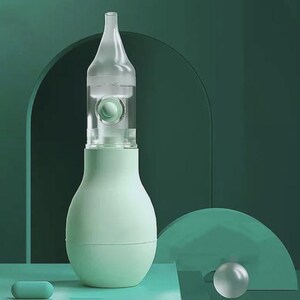 May include: A light green nasal aspirator with a clear, transparent tip and a bulb-shaped body. The aspirator has a clear chamber with a small green ball inside. A small, light green capsule is at the bottom.