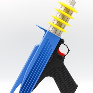 Puede incluir: Una pistola de calafateo azul y negra con un gatillo rojo. La pistola presenta una serie de anillos amarillos alrededor de la boquilla. El mango es negro y texturizado para un mejor agarre.