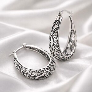 il_fullxfull.7732441927_glmq.jpg Elegant silver-toned hoop earrings with intricate ornate engraving. main image 2