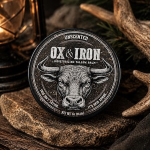 May include: A round black container of Ox & Iron unscented moisturizing tallow balm. The label features a white bull illustration, the text "UNSCENTED," "OX & IRON," "MOISTURIZING TALLOW BALM," "THIS ISN'T LOTION," "IT'S SKIN ARMOR," and "NET WT. 2oz (59.15g)."