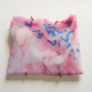 Può includere: Opera d'arte astratta con una combinazione di rosa, bianco e blu. Il pezzo presenta un design a strati con colori vorticosi e solidi. Aste color rame sono attaccate ai bordi.