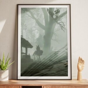 Puede incluir: Una impresi&oacute;n de arte mural vertical enmarcada que muestra la silueta de un jinete a caballo atravesando un bosque denso y lleno de niebla. La escena incluye una peque&ntilde;a estructura de madera con techo de paja y un gran &aacute;rbol prominente al fondo.