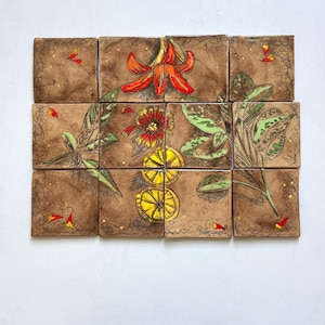 Puede incluir: Un conjunto de nueve azulejos de cerámica con fondo marrón y diseño floral. Los azulejos presentan una flor roja, hojas verdes y limones amarillos. Los azulejos están dispuestos en forma de cuadrícula.