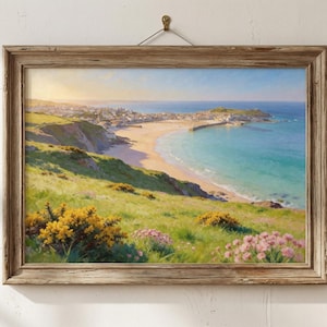 Puede incluir: Pintura de paisaje enmarcada que representa una escena costera con una playa de arena, agua turquesa y un pueblo en la distancia. La pintura está en un marco de madera rústico, con hierba verde y flores amarillas y rosas.