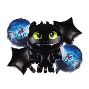 May include: A set of black foil balloons featuring a cartoon dragon character with large green eyes. Two round balloons display a scene with two figures, and two star-shaped balloons complete the set. The balloons are designed for a party or celebration.