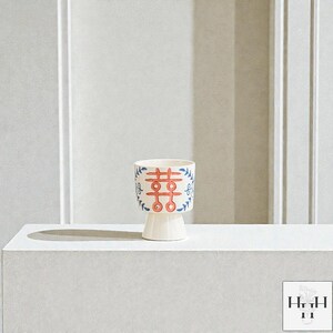 Puede incluir: Una maceta de cer&aacute;mica color crema con base de pedestal. La maceta presenta un dise&ntilde;o rojo y azul con un s&iacute;mbolo de doble felicidad y detalles florales. Adecuada para plantas peque&ntilde;as, a&ntilde;ade un toque decorativo.