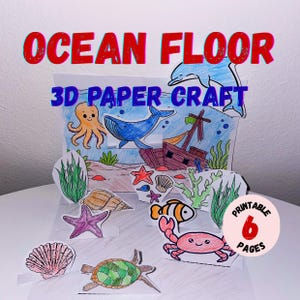 May include: A colorful 3D paper craft scene labeled "OCEAN FLOOR" with a dolphin, whale, octopus, and sunken ship. Additional paper cutouts include a crab, fish, starfish, and seashell. The craft is labeled "3D PAPER CRAFT" and "Printable 6 Pages."