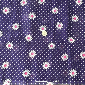 Peut inclure: Gros plan sur un tissu bleu fonc&eacute; orn&eacute; de pois blancs et de motifs de fleurs de marguerite. Les marguerites ont des p&eacute;tales blancs et des centres roses. Id&eacute;al pour les v&ecirc;tements ou les travaux manuels.
