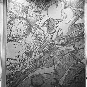 May include: A gray manga-style art portfolio with a detailed black and white illustration. The artwork depicts a dynamic scene with figures, rocks, and water, all rendered in a detailed, textured style. The portfolio has a silver border and a metal stand.