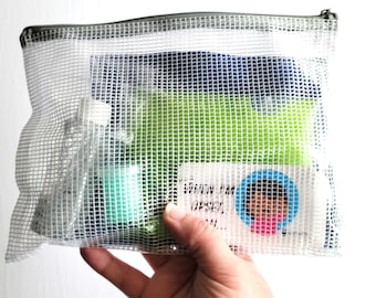 May include: A clear mesh zippered pouch with a green, blue, and white item inside. The pouch has a white label with the text "When I'm Upset" and a cartoon image of a child.