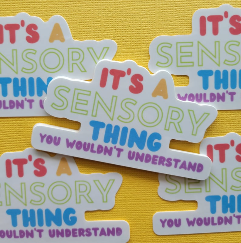 May include: Four white stickers with colorful text that reads "It's a sensory thing you wouldn't understand". The stickers are on a yellow background.