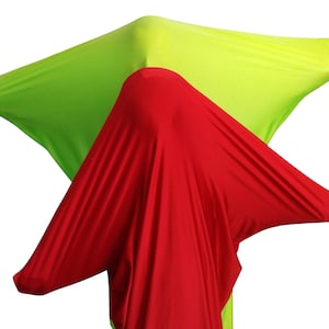 May include: A red and green stretchy fabric sensory toy. The fabric is thin and has a smooth texture. The toy is being stretched and pulled in different directions.