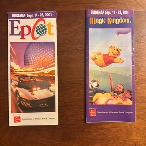 K&ouml;nnte beinhalten: Zwei Vintage-F&uuml;hrer vom 17. bis 23. September 2001. Einer zeigt das Epcot-Logo mit einem Auto und Spaceship Earth. Der andere zeigt Winnie the Pooh und Kinder im Magic Kingdom. Beide werden von Eastman Kodak gesponsert.