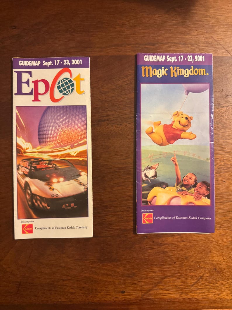 K&ouml;nnte beinhalten: Zwei Vintage-F&uuml;hrer vom 17. bis 23. September 2001. Einer zeigt das Epcot-Logo mit einem Auto und Spaceship Earth. Der andere zeigt Winnie the Pooh und Kinder im Magic Kingdom. Beide werden von Eastman Kodak gesponsert.